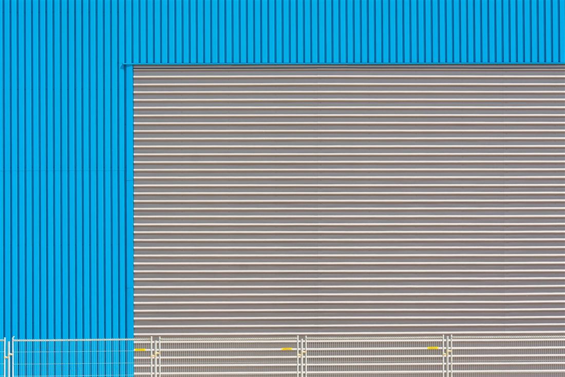 Blue industrial building with a large roller shutter door