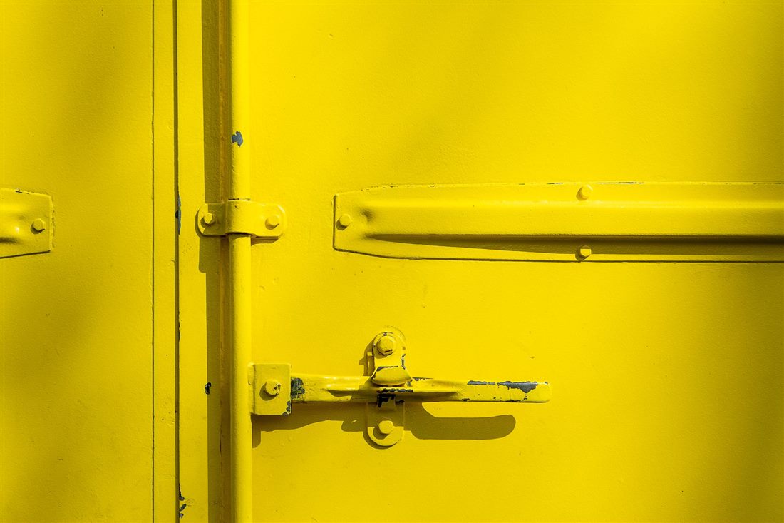Close-up of a yellow industrial door panel and latch