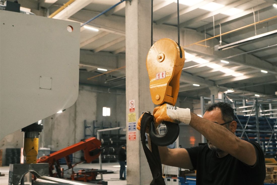 Industrial technician operating lifting equipment in a factory