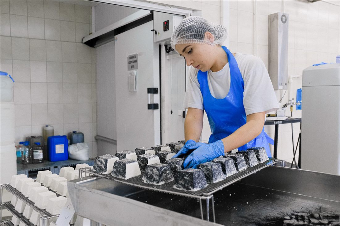 Food factory worker beside a hygienic sliding door in a cold room