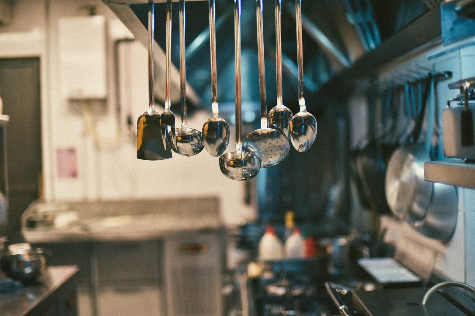 Stainless steel utensils hanging in a professional commercial kitchen