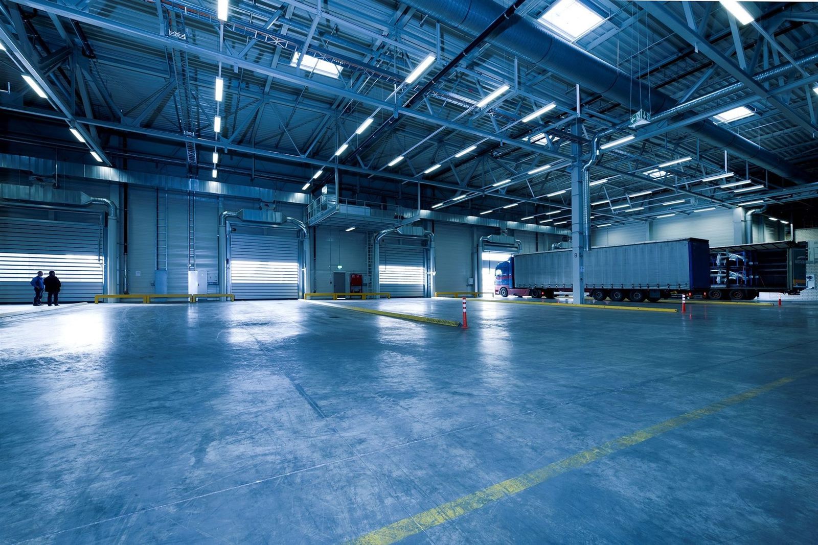 Spacious warehouse interior with multiple loading dock doors and a truck